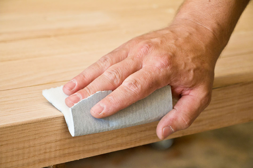 Przecieranie drewnianej powierzchni papierem ściernym